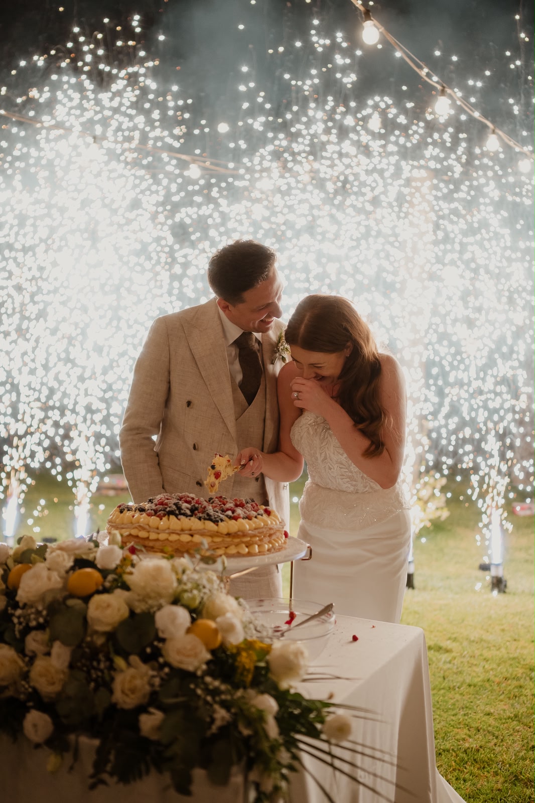 Jessica e Seb tagliano la torta nuziale mentre le stelline illuminano la sera