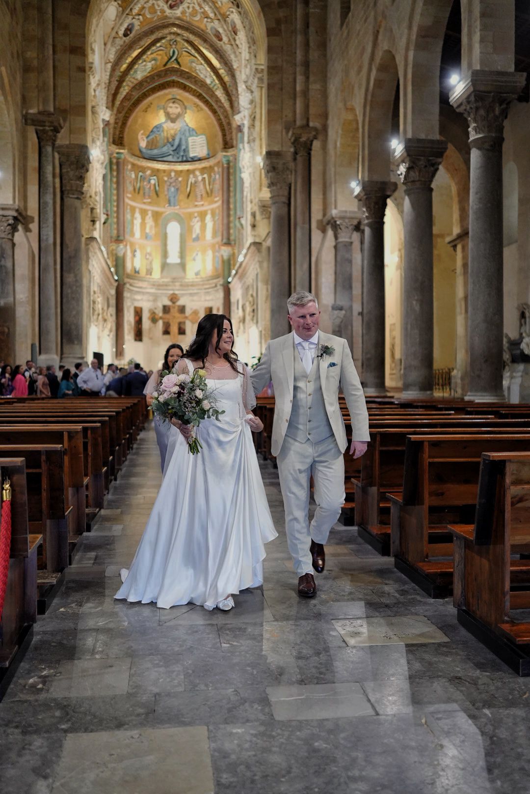 Golden mosaic interior of a Sicilian cathedral during a wedding