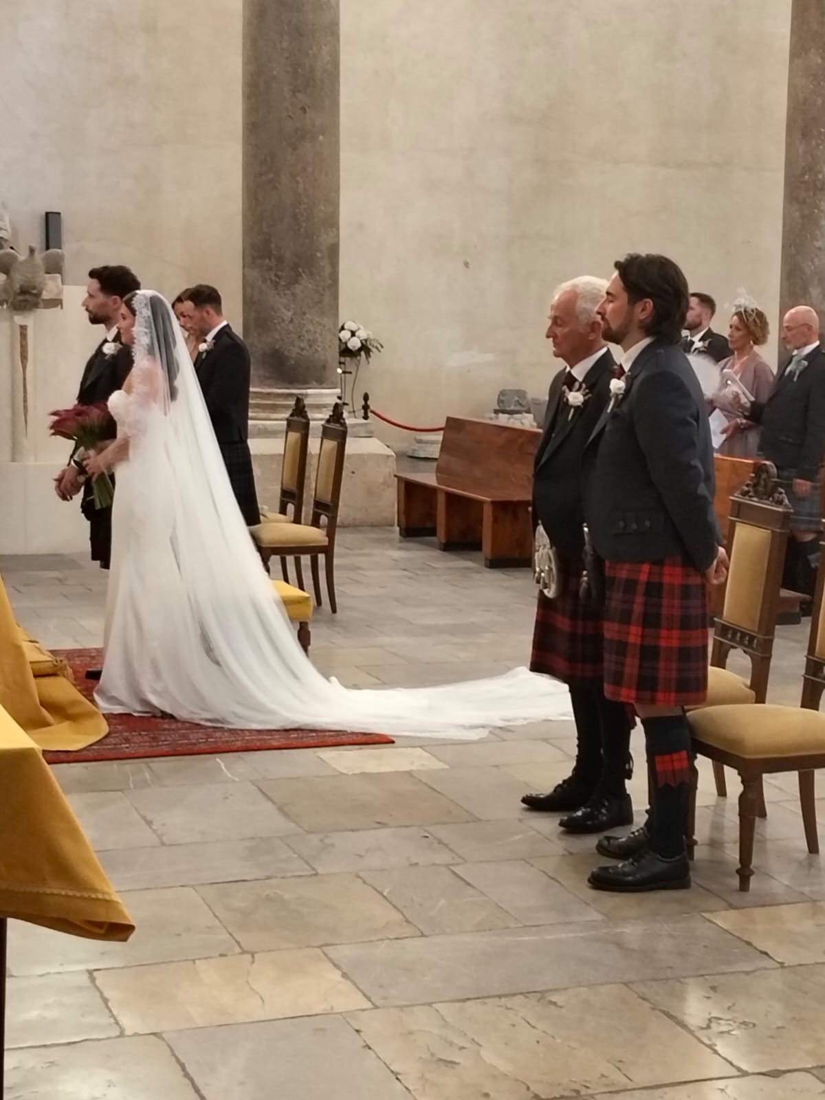 Wedding ceremony inside a historic Sicilian church with soft light and floral decoration
