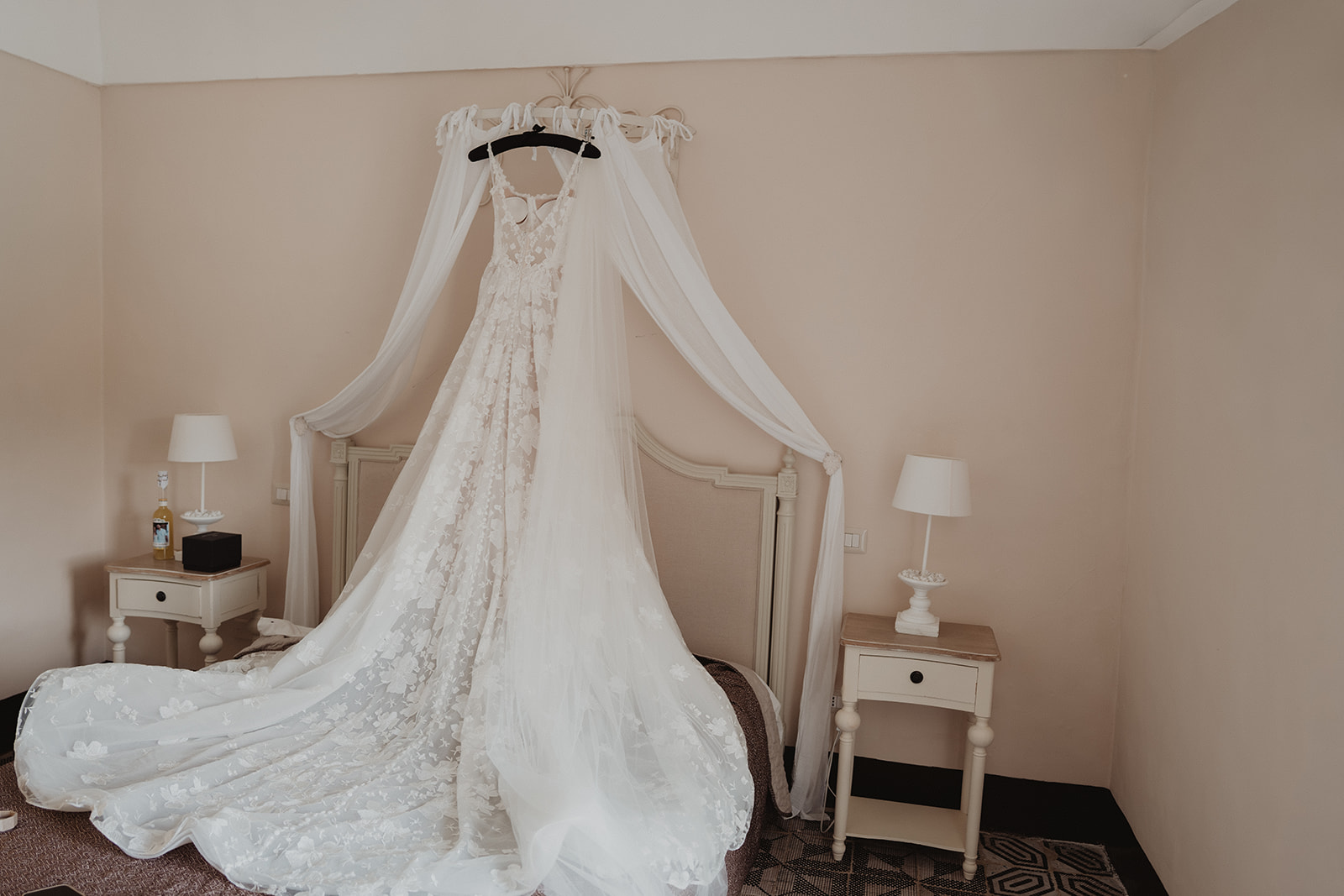 L’abito da sposa in pizzo e il velo di Lidia appesi sopra il letto al Borgo del Carato