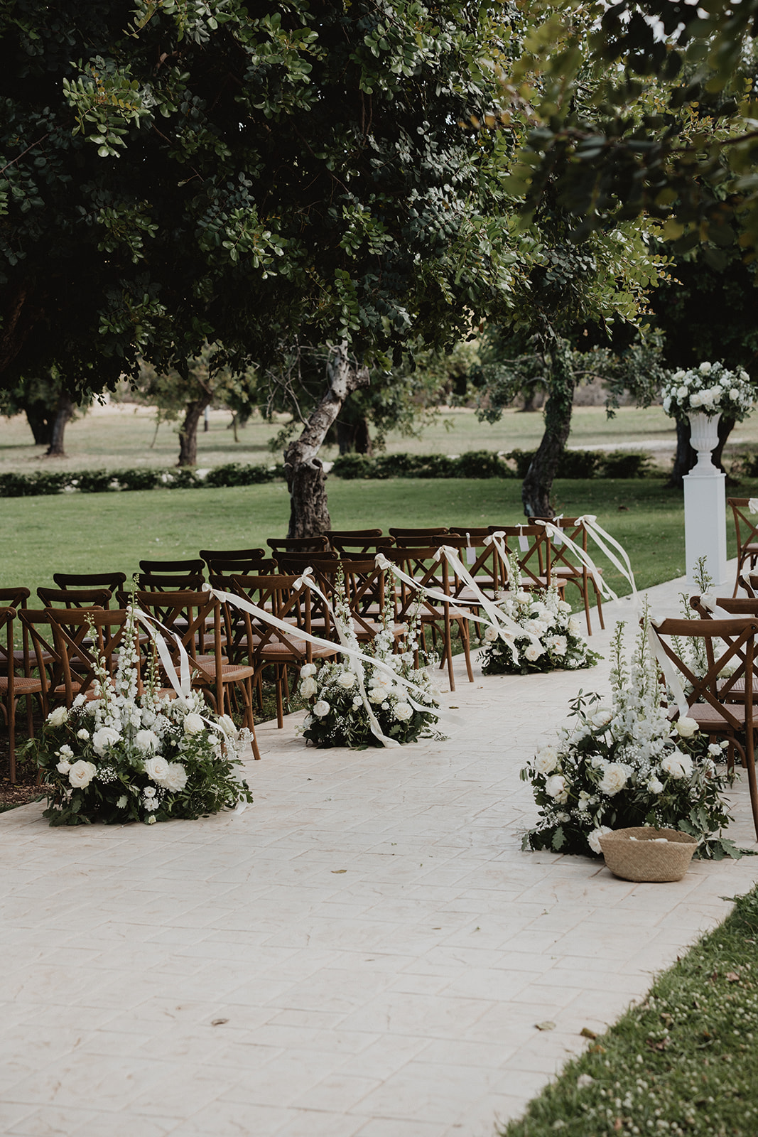 La navata della cerimonia al Borgo del Carato, decorata con fiori bianchi e nastri sotto gli alberi