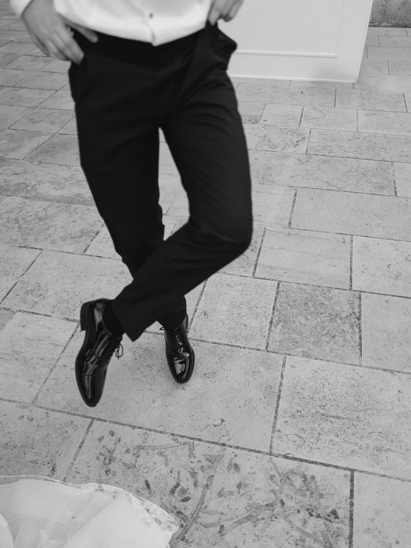 Un primo piano in bianco e nero di piedi che ballano con scarpe di vernice