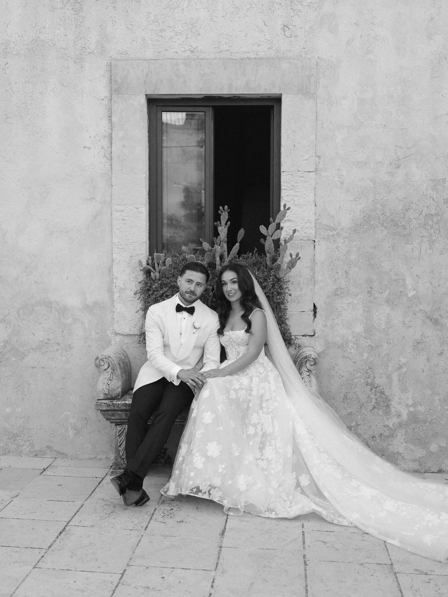 Una foto in bianco e nero di Lidia e Rian seduti su una panchina di pietra tra i cactus