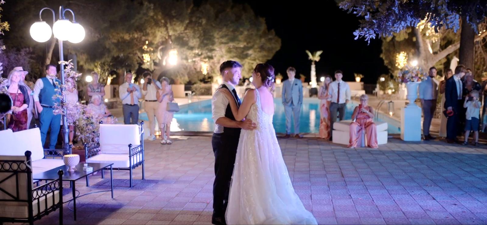 Il primo ballo degli sposi nel parco dell’Excelsior Palace, con la piscina illuminata alle spalle