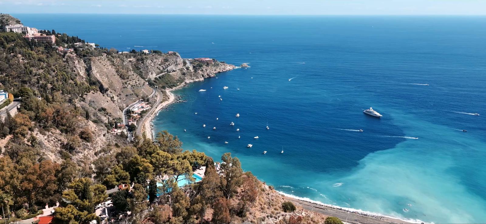 La costa ionica intorno a Taormina vista dall’alto, con le barche sul mare turchese