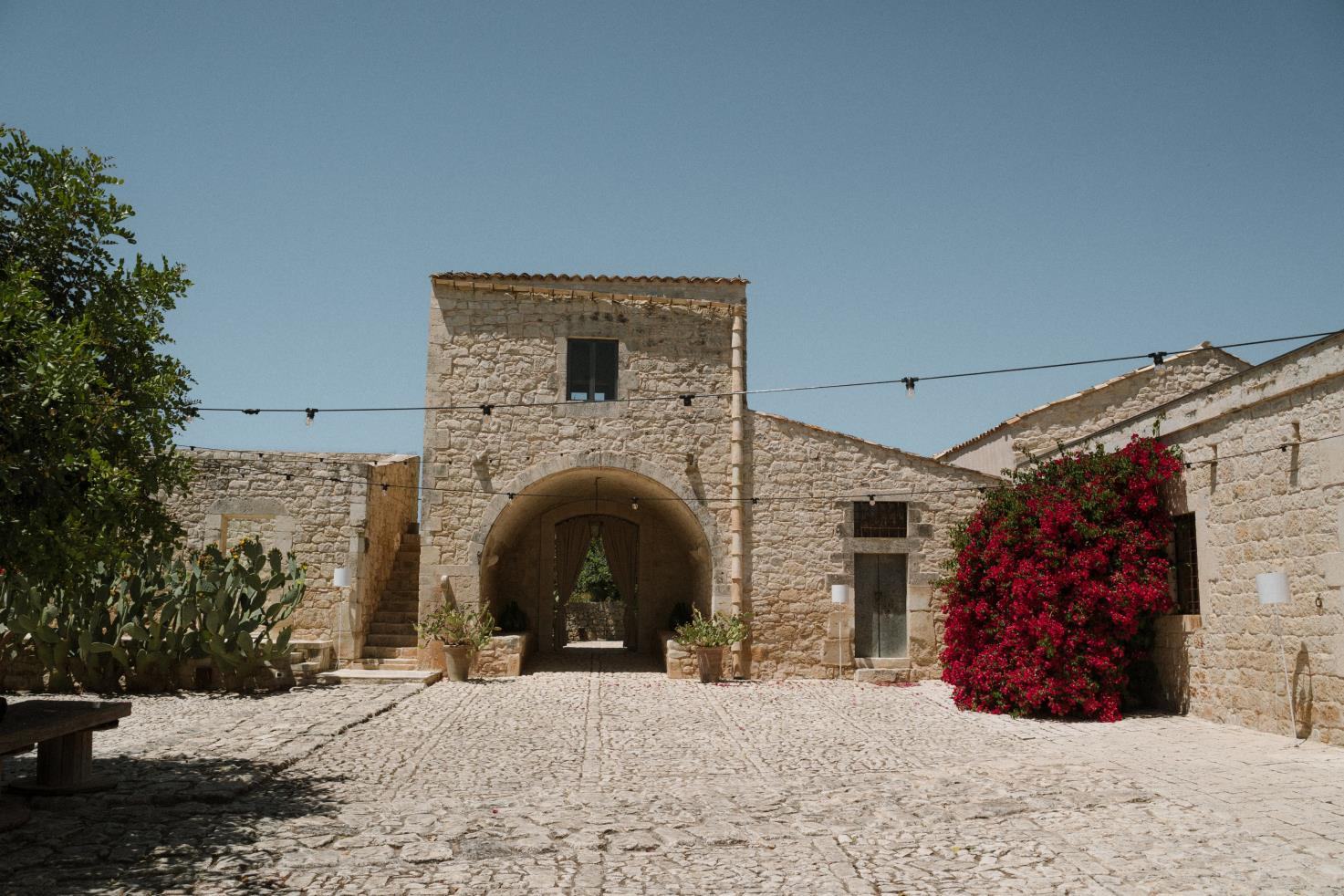 Il baglio de La Chiusa Country House, location per matrimoni a Rosolini (Siracusa), con l’ingresso ad arco e la bouganville